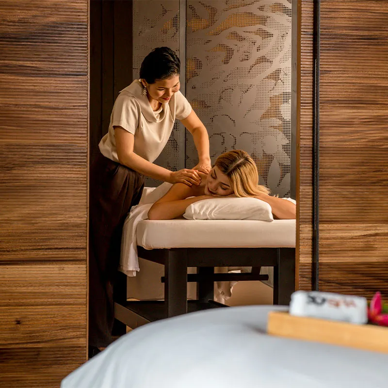 Professional therapist preparing in-room massage setup in Bangkok hotel